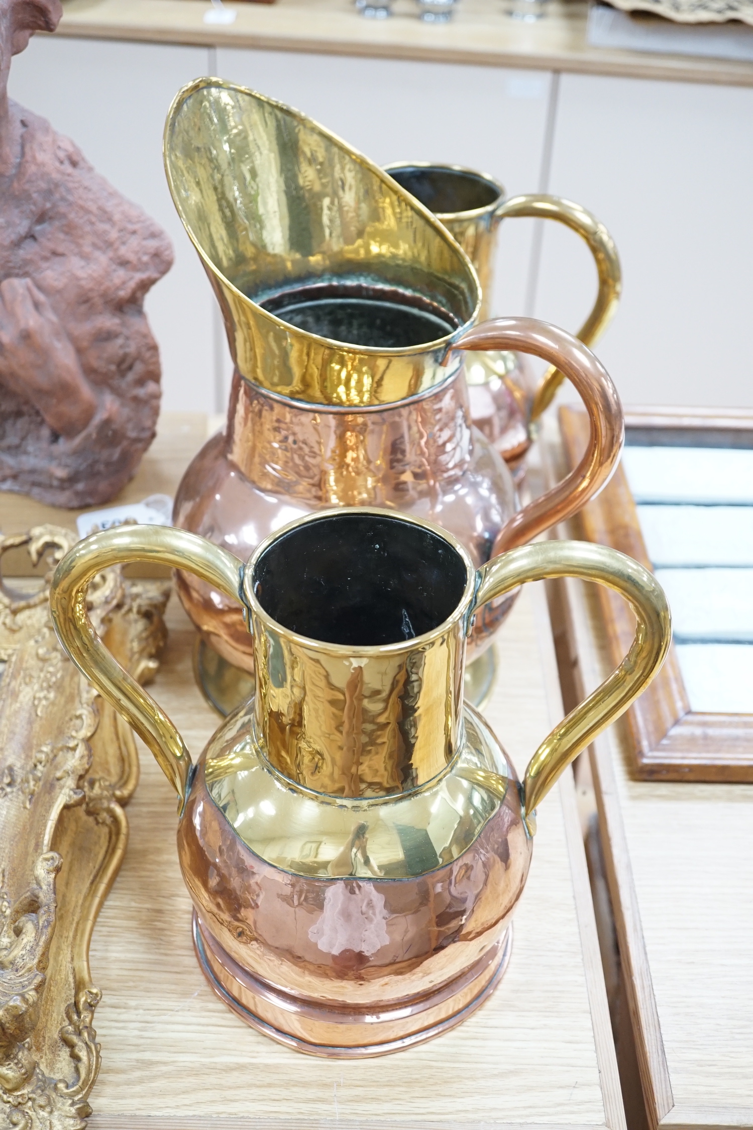 A pair late 19th century copper and brass twin handled vases and a similar jug, the largest 35cm high (3)